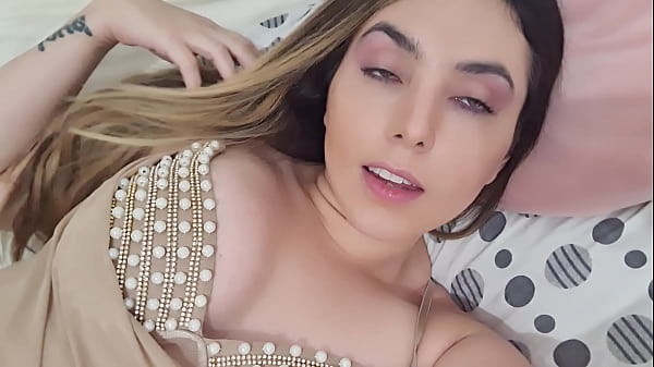 Boliviana de blusa con perlitas dejándose mirar en la pieza